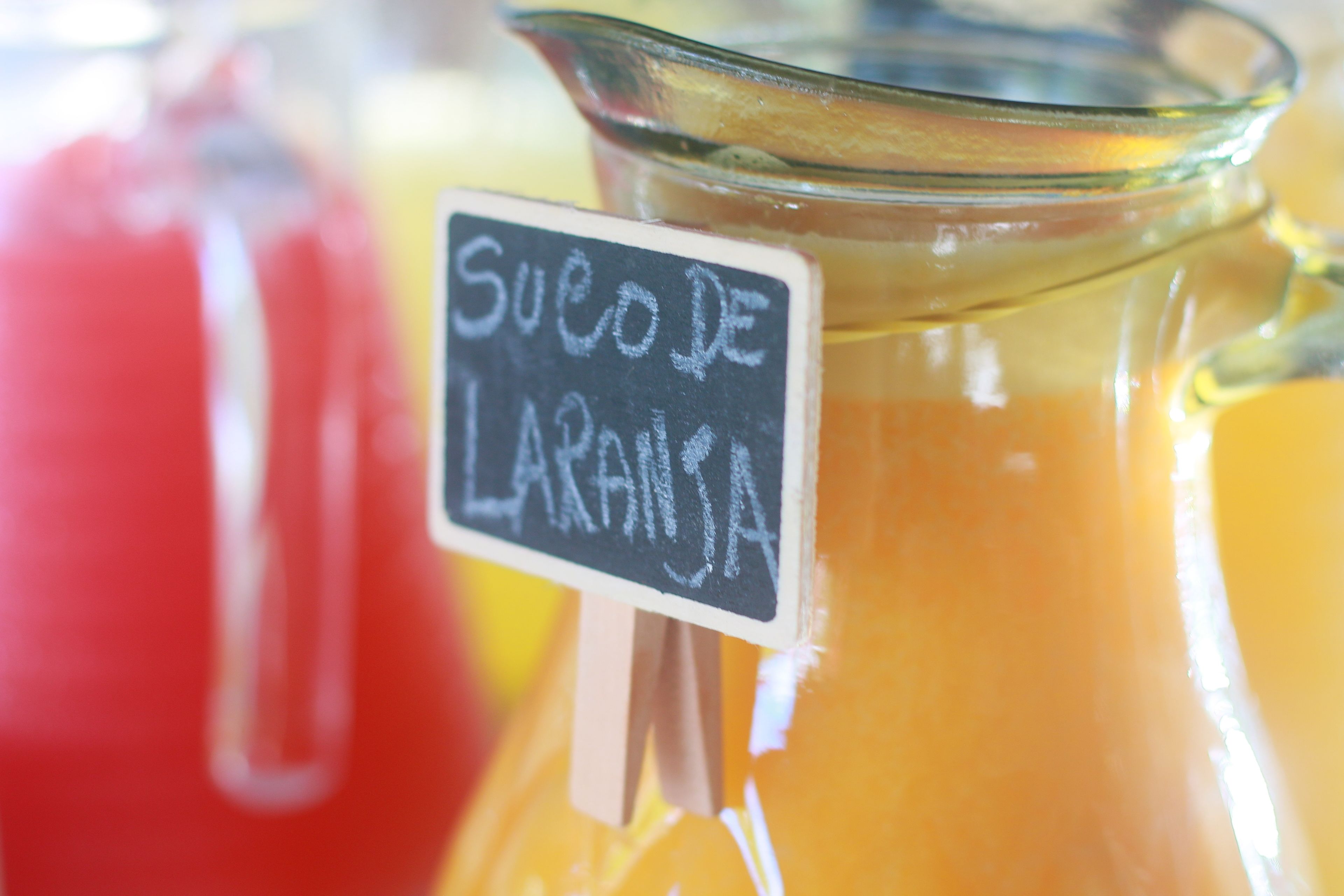 Lasinen kannu, jossa on etiketti, jossa lukee: ”Suco de Laranja”.