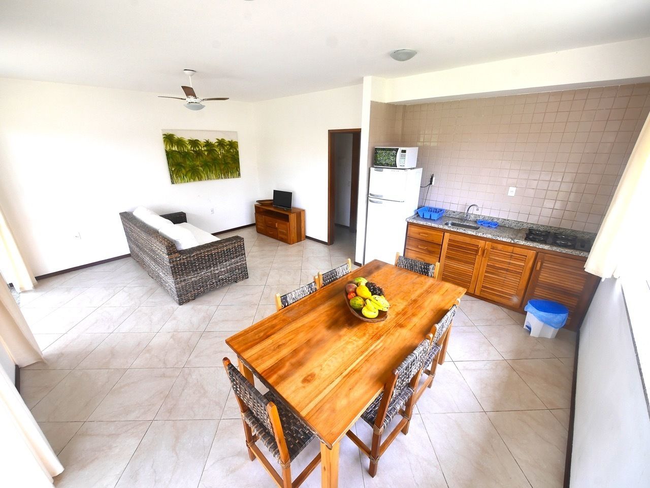 A compact living space with a dining area, kitchenette, and a ceiling fan.