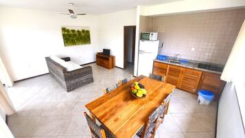 A compact living space with a dining area, kitchenette, and a ceiling fan.