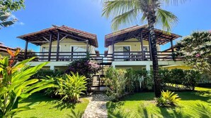 A hotel with two-story buildings, a stone pathway, and lush greenery. - Village Mutà (Porto Seguro)