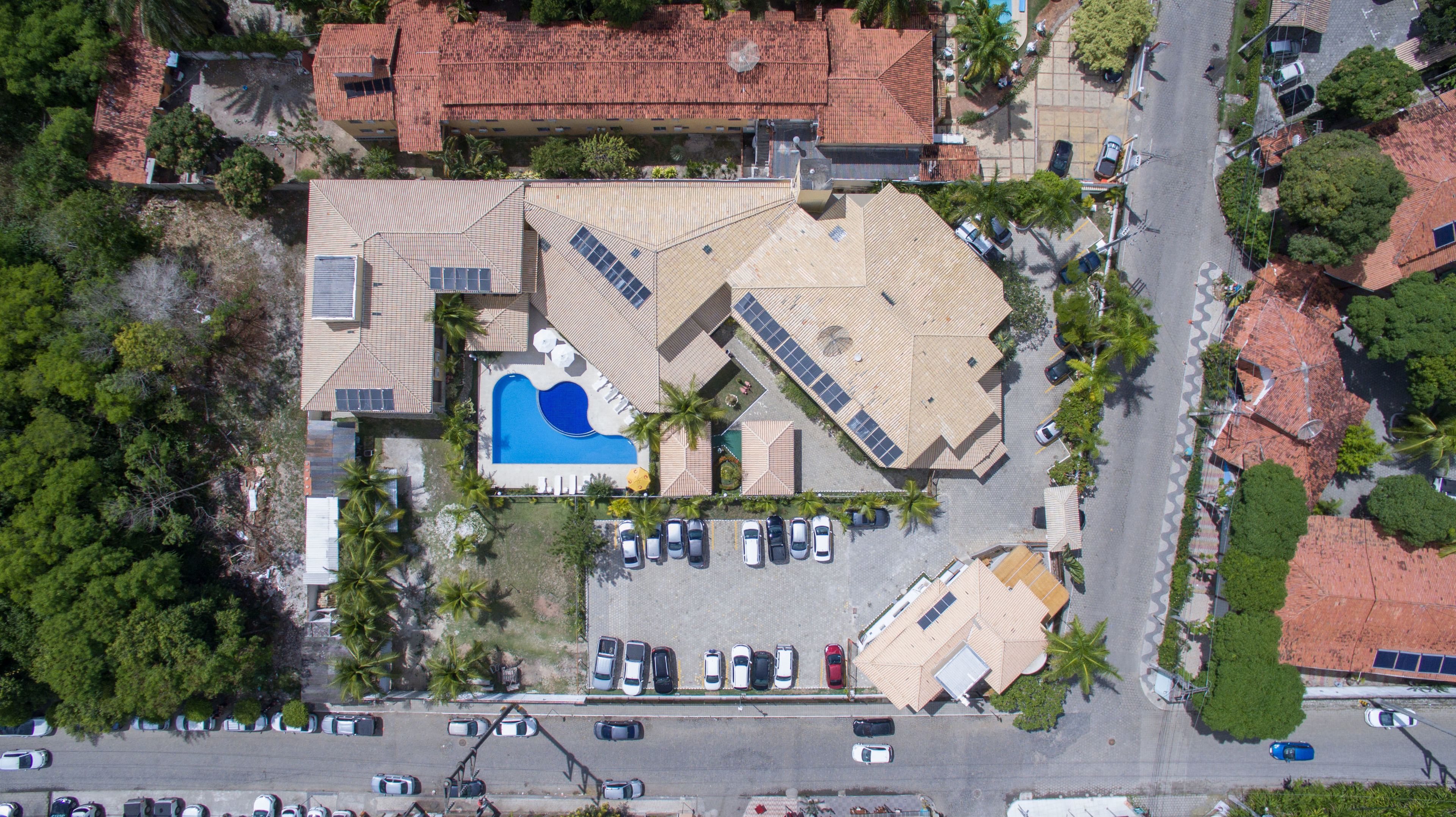 Vue aérienne d’une propriété dotée d’une piscine, de plusieurs places de stationnement et comprenant un mélange de bâtiments résidentiels et commerciaux.