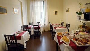 A dining area with tables set for meals, featuring a variety of dishes and a coffee machine. - B&B Marbo Florence (Florence)