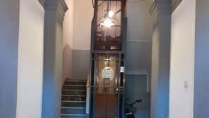A hallway with a tiled floor, a staircase, and a bicycle parked against the wall. - B&B Marbo Florence (Florence)