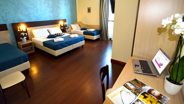 A hotel room with two beds, a desk with a laptop, and a chair. - B&B Marbo Florence (Florence)