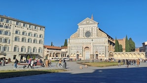 A historic building with a prominent clock tower, surrounded by a public square with people and vehicles. - B&B Marbo Florence (Florence)