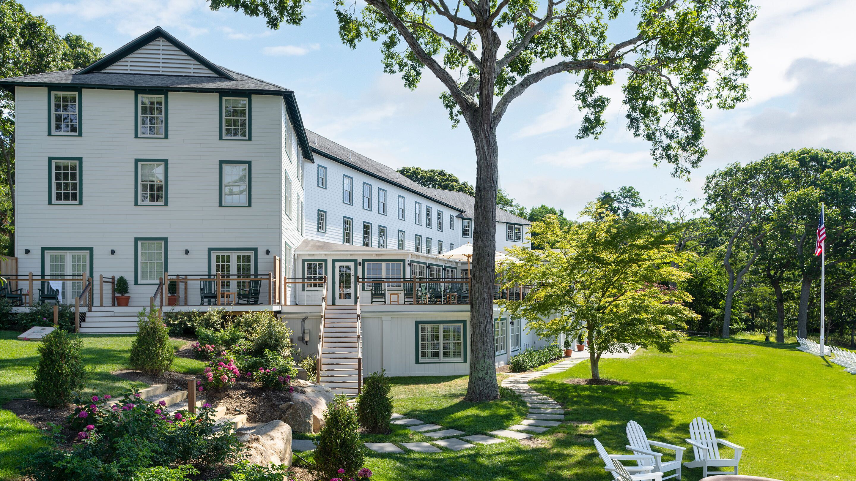 A large, multi-story building with a covered outdoor seating area and a well-maintained garden.