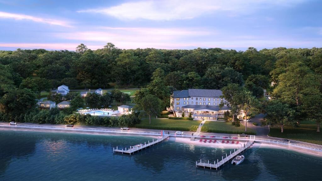 A lakeside property with a dock, a large building, and surrounding greenery.