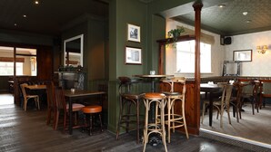 A restaurant with wooden furniture, a bar area, and framed pictures on the walls. - The Avenue (Durham)