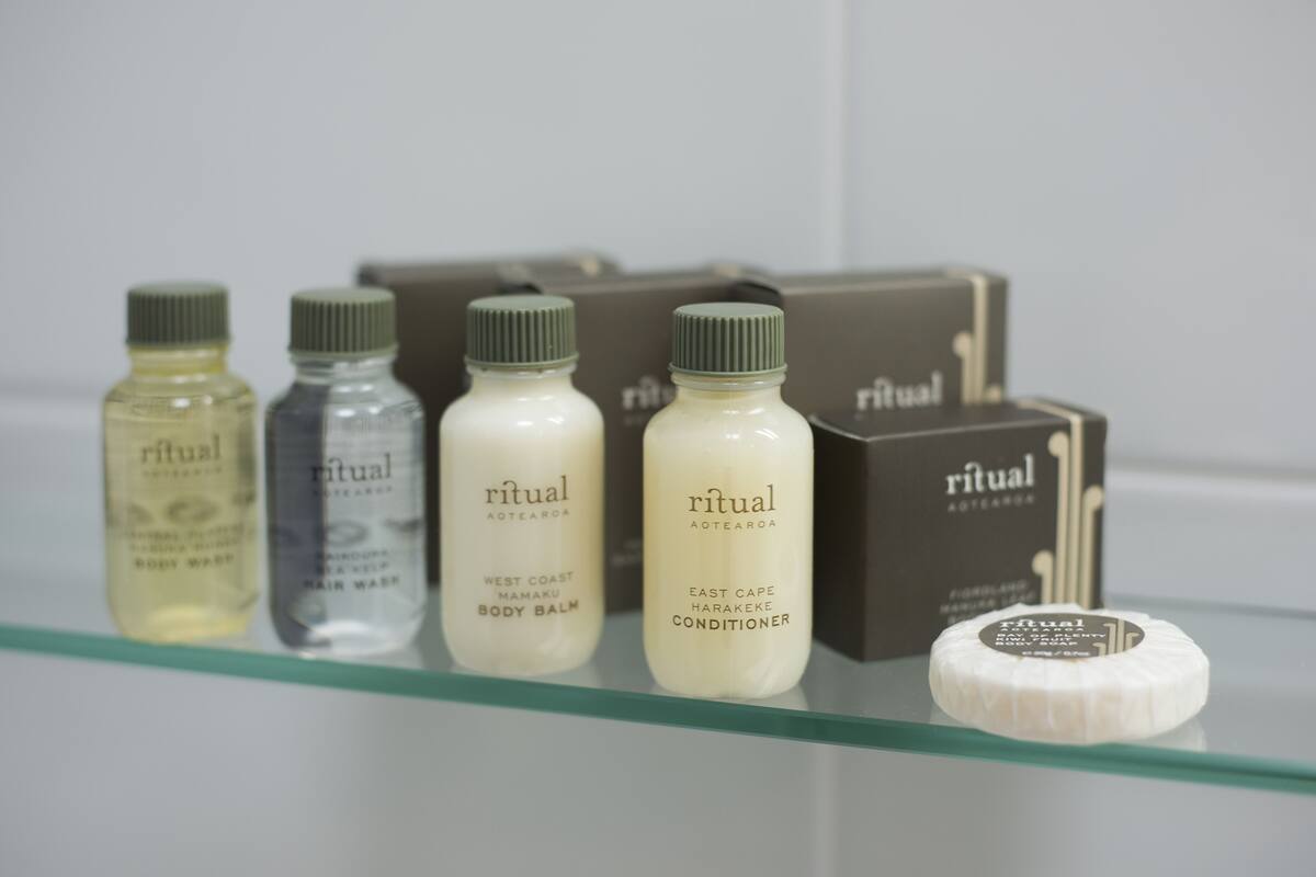 A shelf with various Ritual brand toiletries including body wash, hair wash, and conditioner.