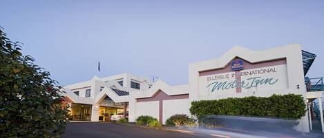 The exterior of the ELLERSLIE INTERNATIONAL MOTOR TOWN hotel with a clear entrance and signage.