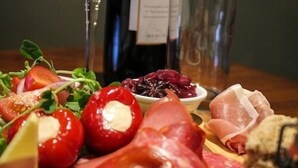 A charcuterie board with various meats, cheeses, and a bottle of wine. - The Charlton Inn (Blandford Forum)