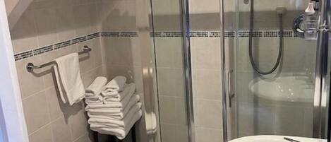 A bathroom with a glass-enclosed shower, a white sink, and a toilet.