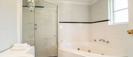 Un baño con ducha de vidrio, bañera blanca y lavabo.