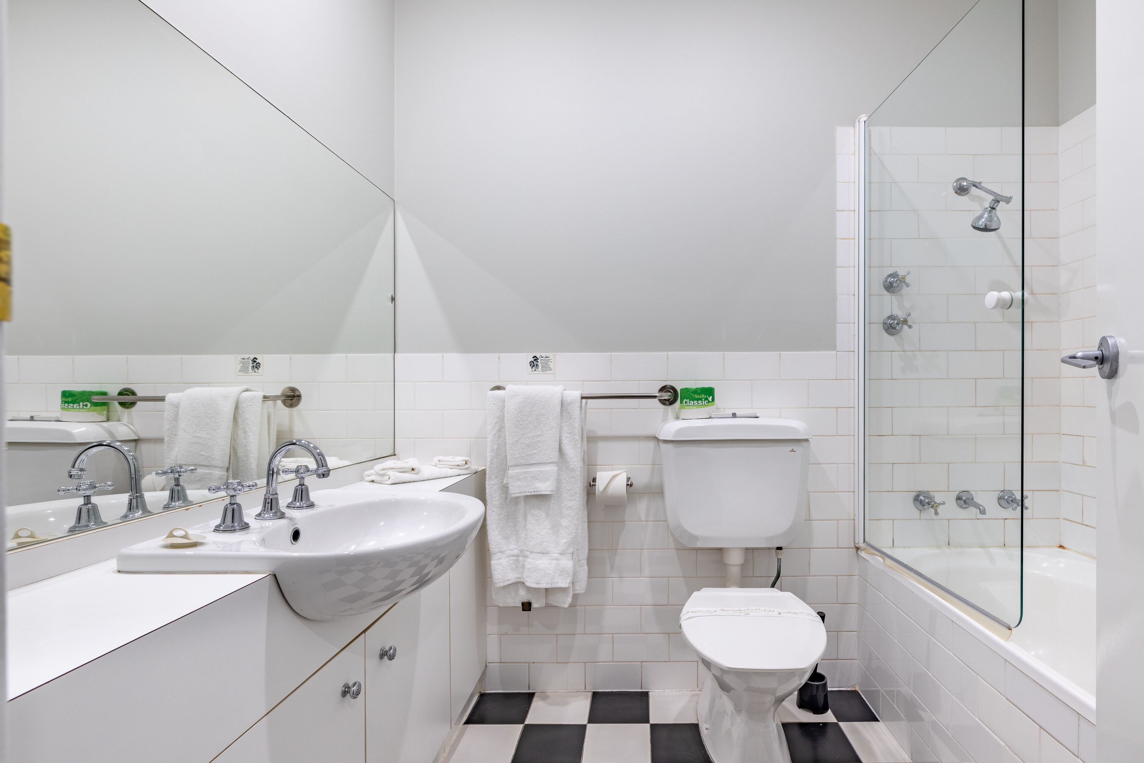 A modern bathroom with a white sink, toilet, and glass-enclosed shower.