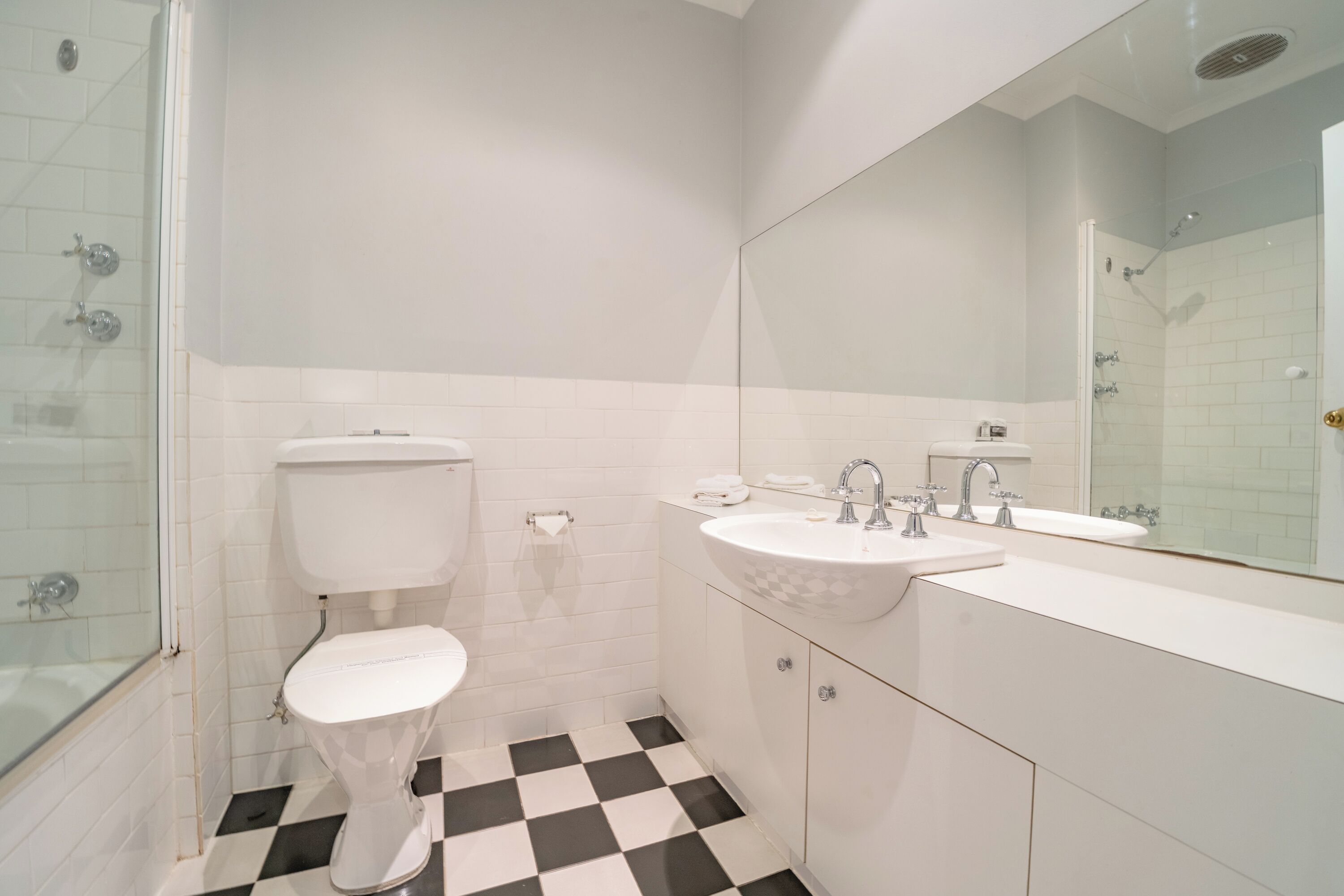 A bathroom with a toilet, sink, and shower.