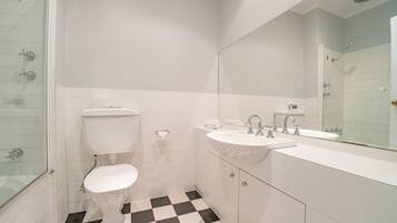 A bathroom with a toilet, sink, and shower.