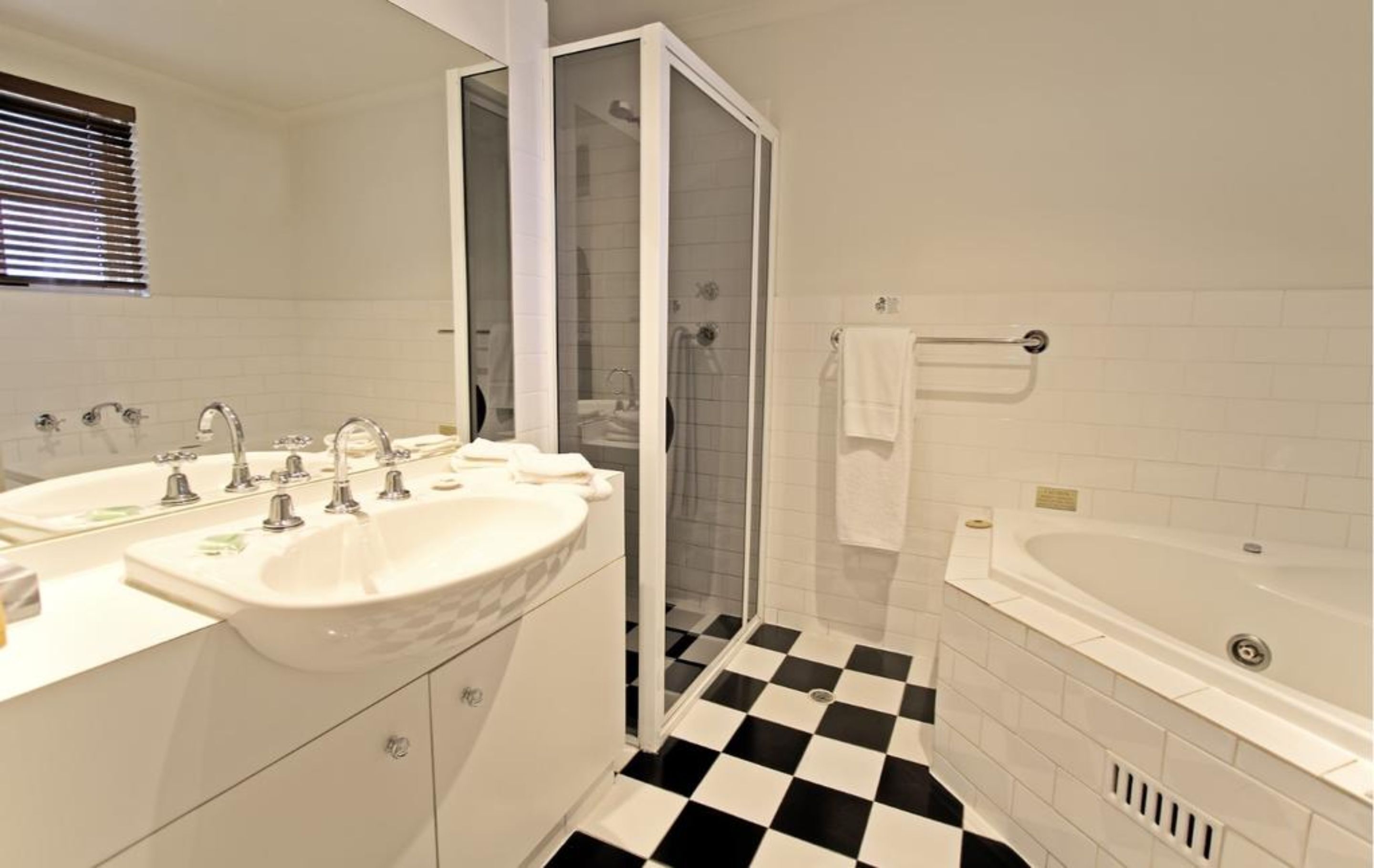 Un baño con dos lavamanos, ducha y bañera.