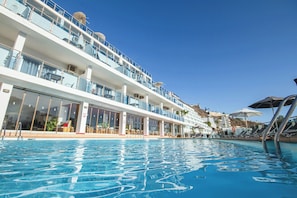 Un navire de croisière doté d’une piscine, de plusieurs ponts et d’espaces de détente en plein air.