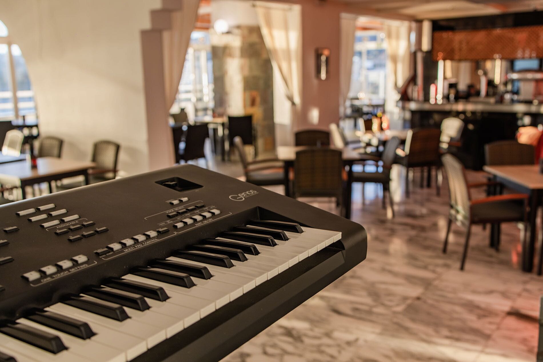 A keyboard in a room with a dining area and a bar.