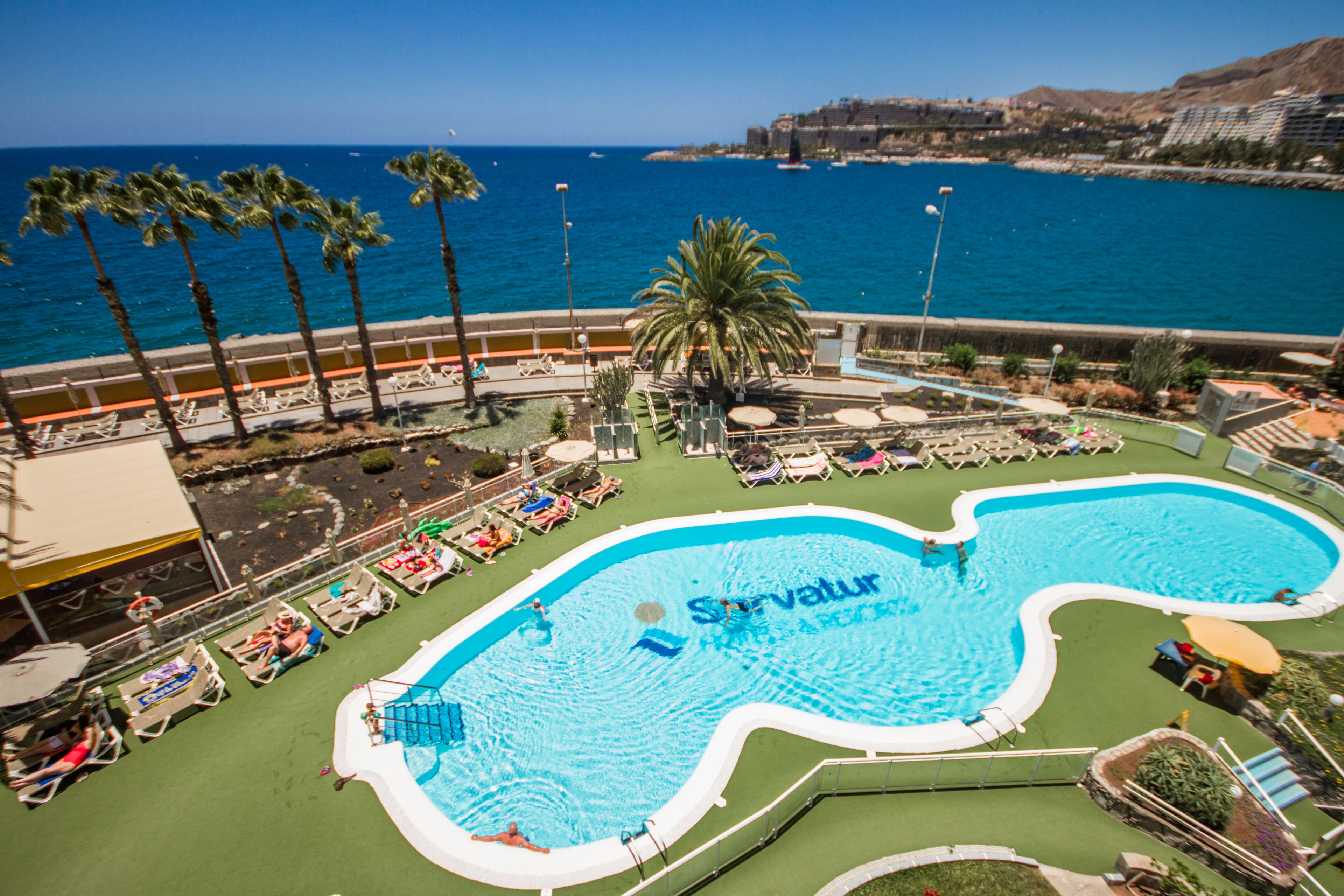 A swimming pool with a unique shape and the word 'Satur' visible in the water.