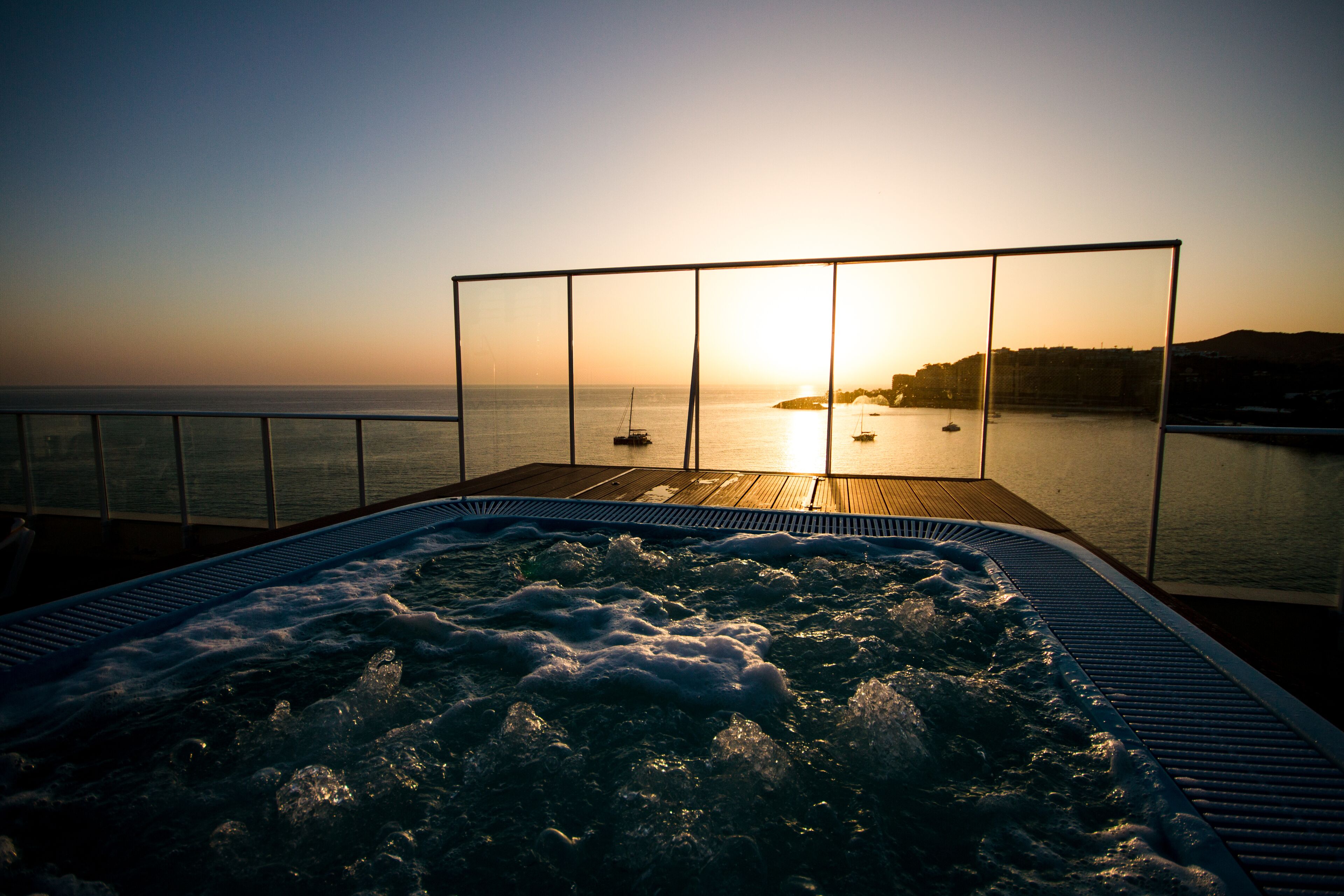 Ein Whirlpool mit Blick auf das Meer und den Sonnenuntergang.