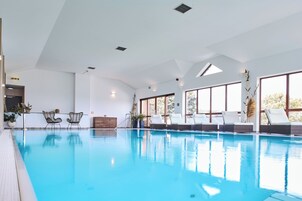 Una piscina techada, sillones reclinables de piscina