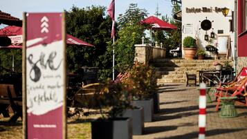A courtyard with outdoor seating, a stone staircase, and a building with a sign reading "Luther-Wi-Fest".