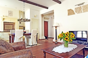 A living room with a wooden coffee table, a sofa, and a dining area with chairs and a table.