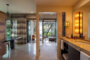 A modern bathroom with a large mirror, a vanity with a sink, and a shower area.