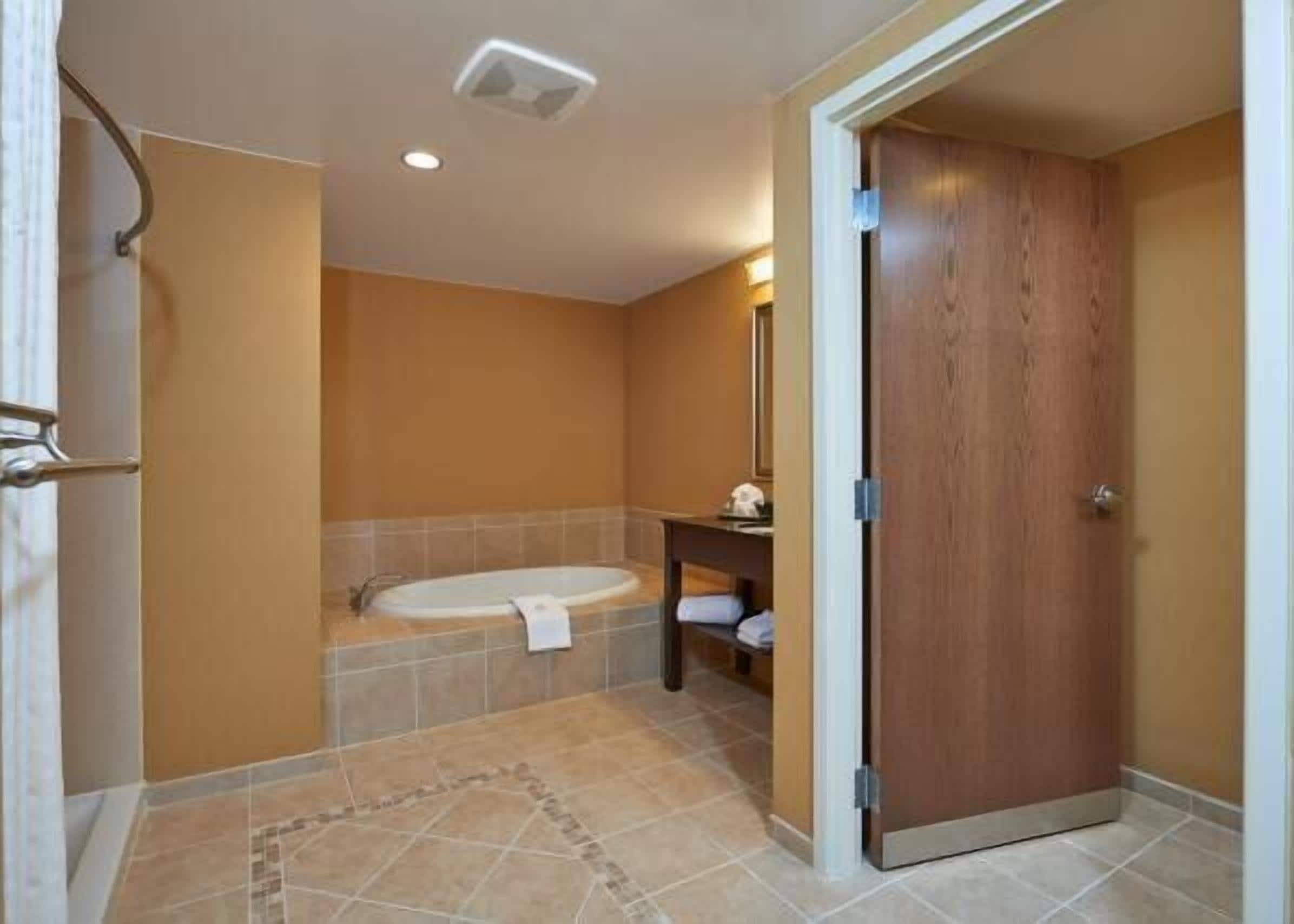 executive suite, 1 king bed, non smoking | bathroom | combined shower/bathtub, free toiletries, hair dryer, towels
