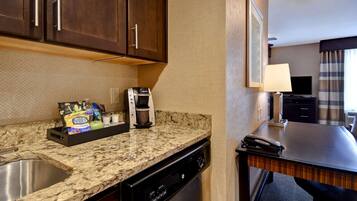 A kitchen with a granite countertop, a coffee maker, a toaster, and a dish soap dispenser.
