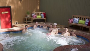 Ein Whirlpool mit einer Holzbank und einer Saunatür.