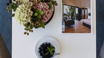 Una revista con una foto de una sala de estar moderna, un cuenco de frambuesas y un arreglo floral.