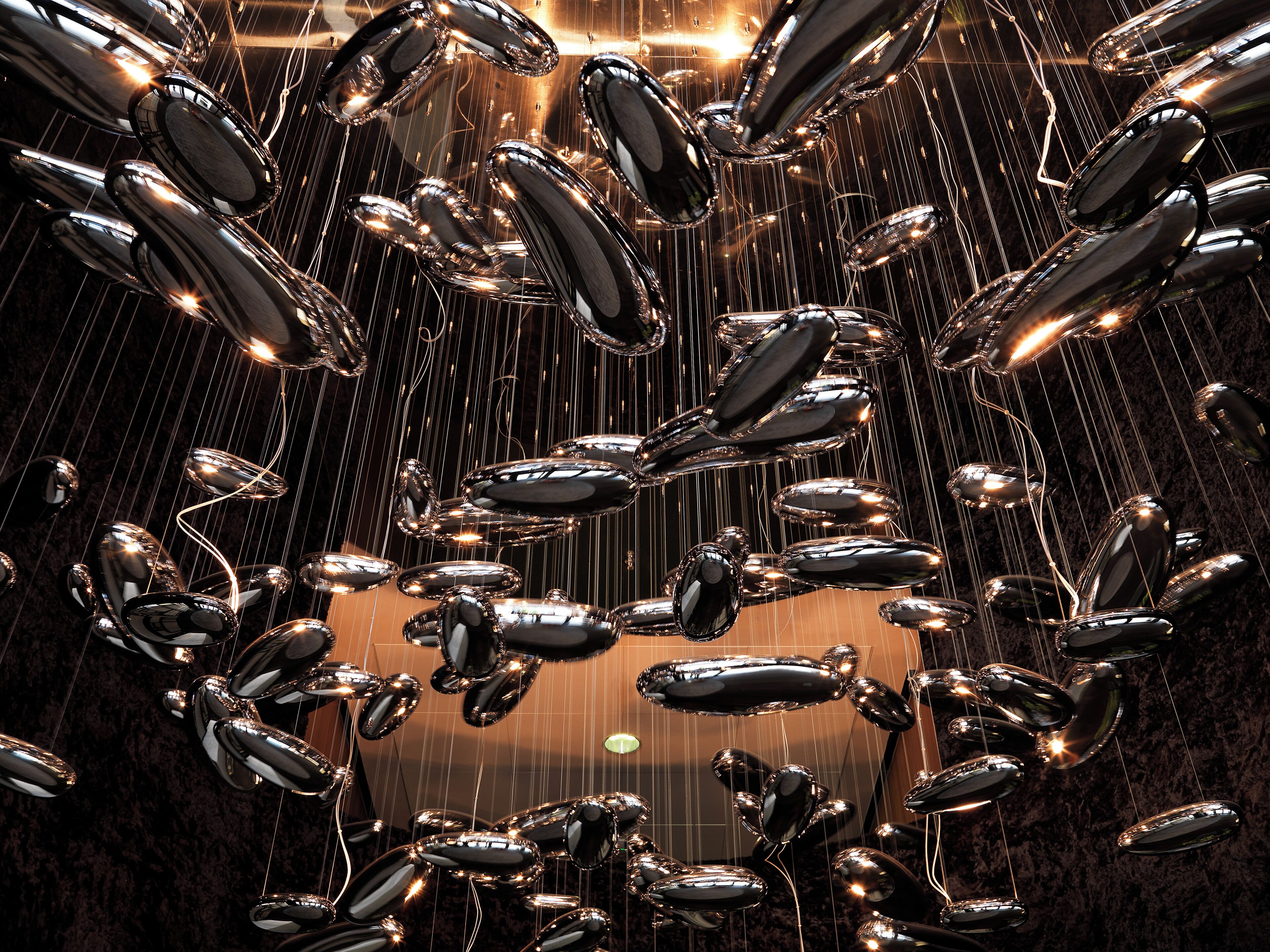 A chandelier with multiple reflective metallic elements.