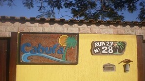 A yellow building with a sign that reads "Cabufa" and "Rua 27 N° 28". - Pousada Cabufa (Cabo Frio)