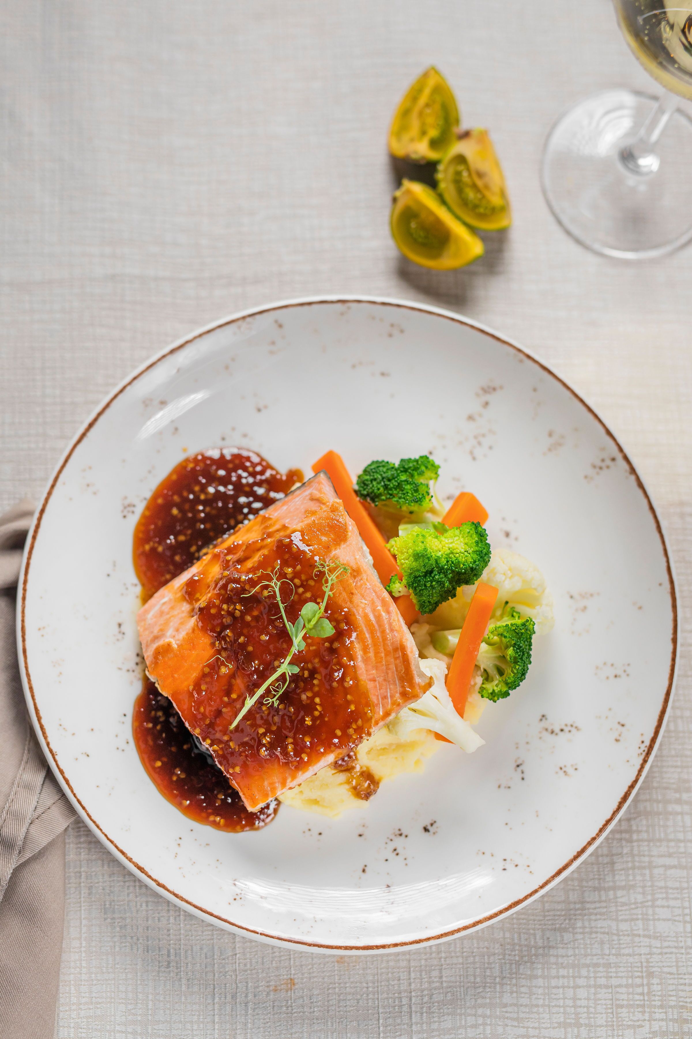Une assiette de nourriture contenant du saumon, des brocolis et des carottes.