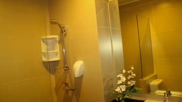 Un baño con ducha, lavamanos, inodoro y espejo.