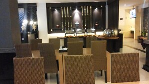 Un espace repas moderne avec une longue table, de nombreuses chaises et des objets décoratifs.
