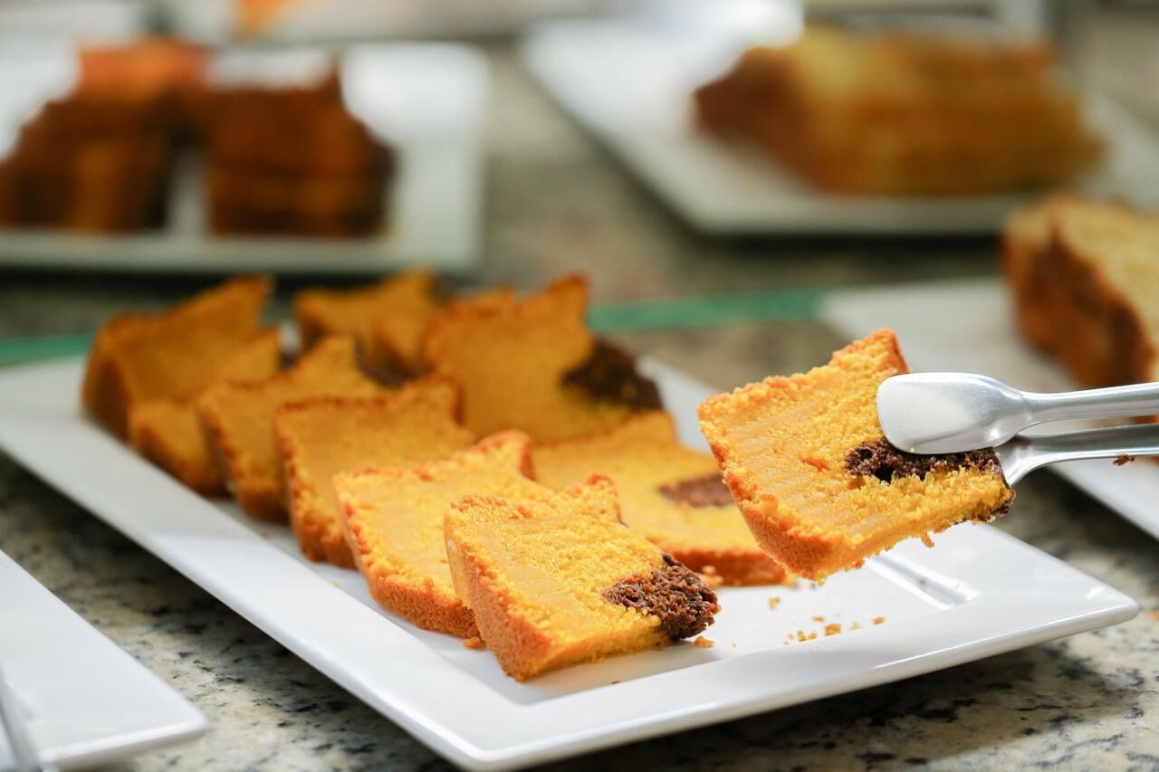A tray of square-shaped, golden-brown desserts on a white plate.
