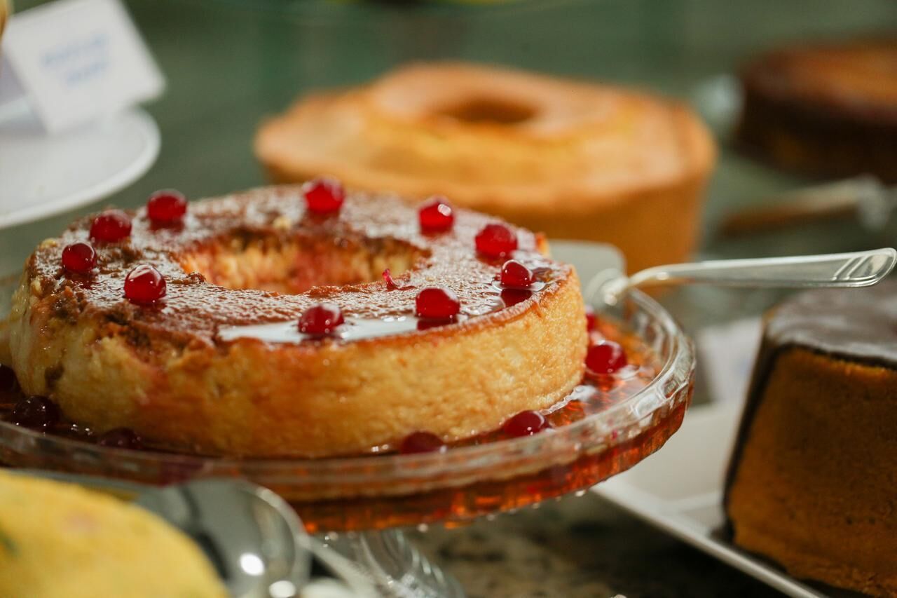 A cake with red berries on a glass plate.