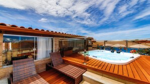 A deck with a hot tub, wooden flooring, and outdoor seating. - Rede Andrade Terra Brasil (Porto Seguro)