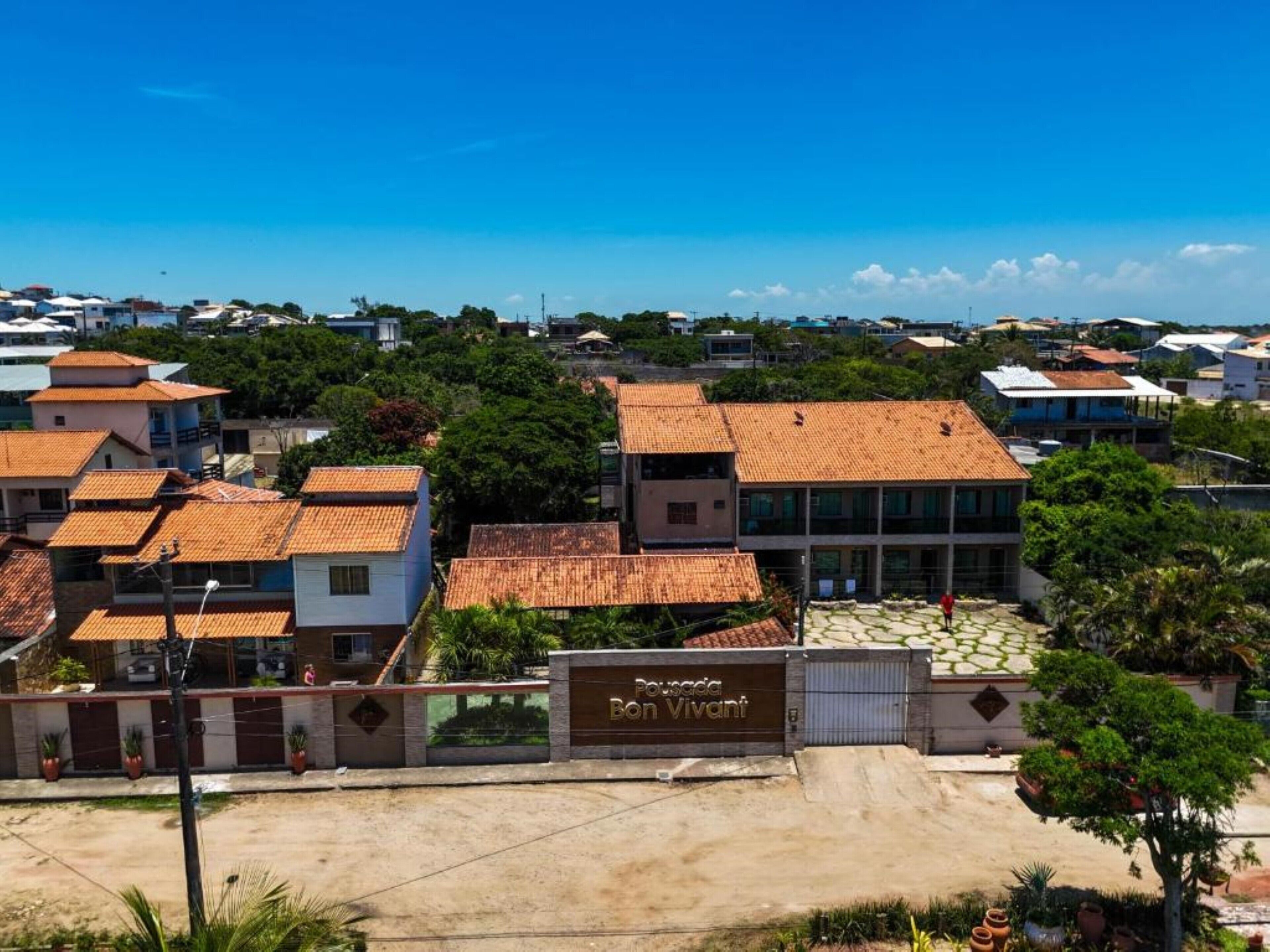 A residential area with a gated entrance labeled "Pousada Bon Vivant".