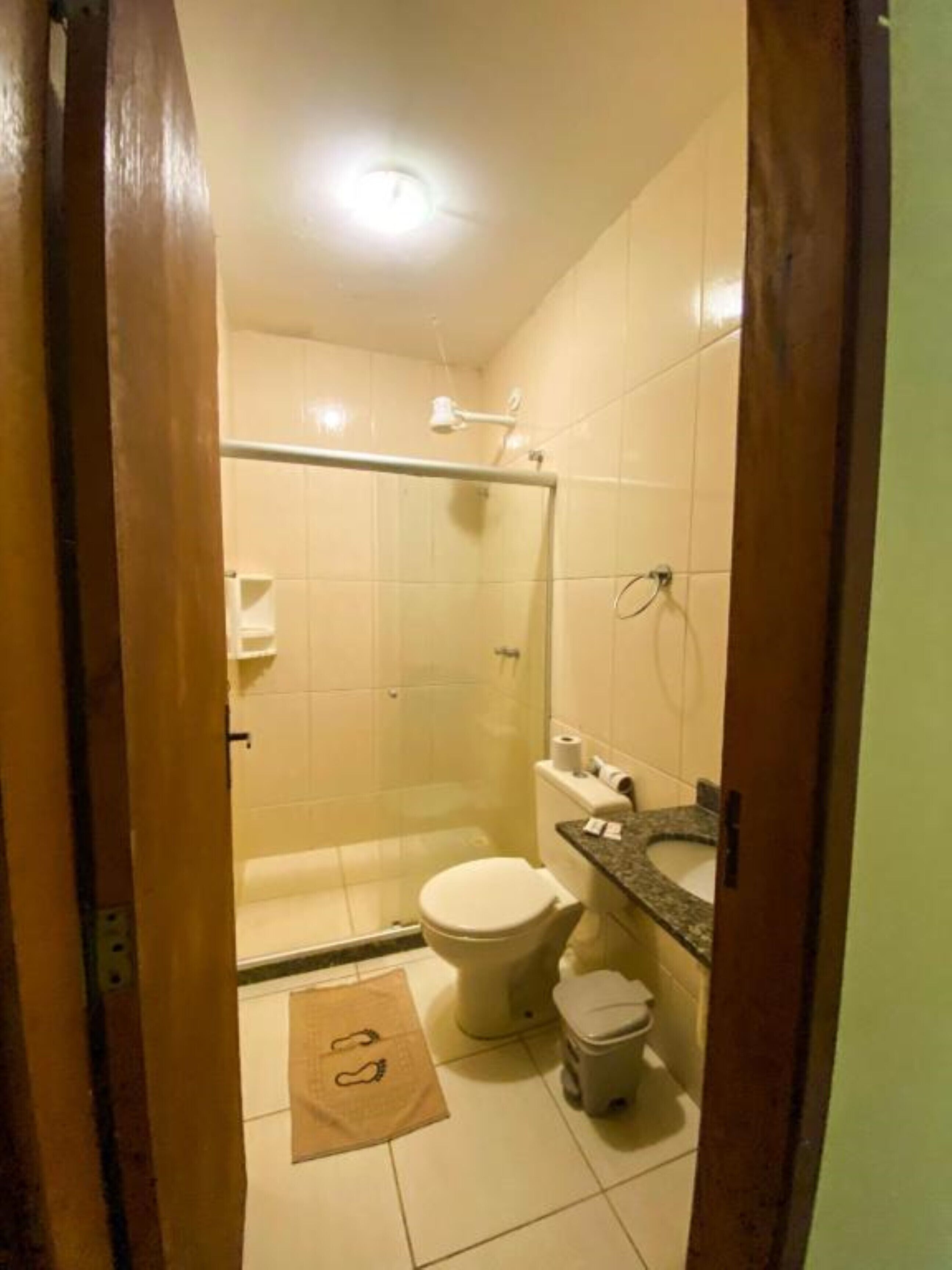 A small bathroom with a shower, toilet, and sink.