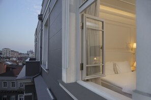 Une chambre d’hôtel avec un lit, une fenêtre et une vue sur le paysage urbain.