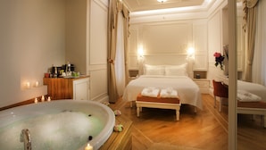 Une chambre d’hôtel luxueuse dotée d’un grand lit, d’un coin salon, d’une baignoire et d’une coiffeuse avec des articles de toilette.
