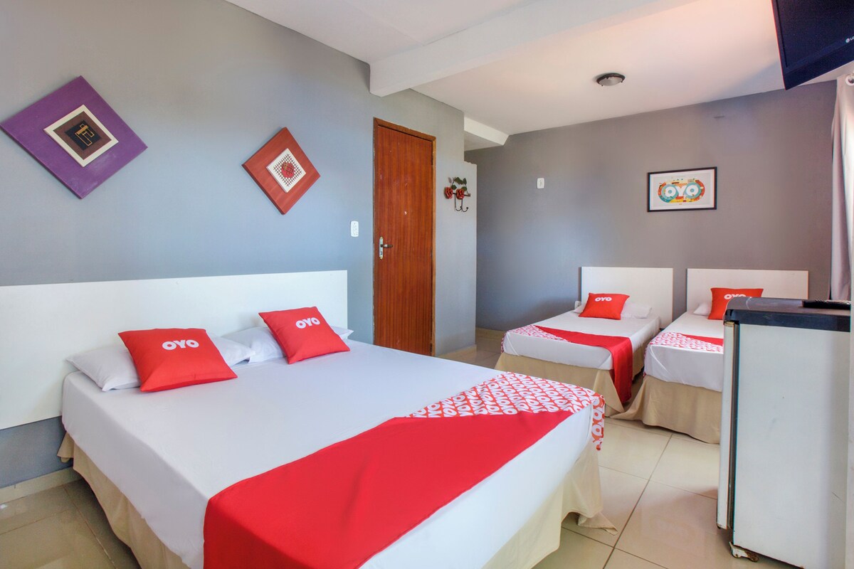 Una habitación de hotel con dos camas, un refrigerador y una puerta.