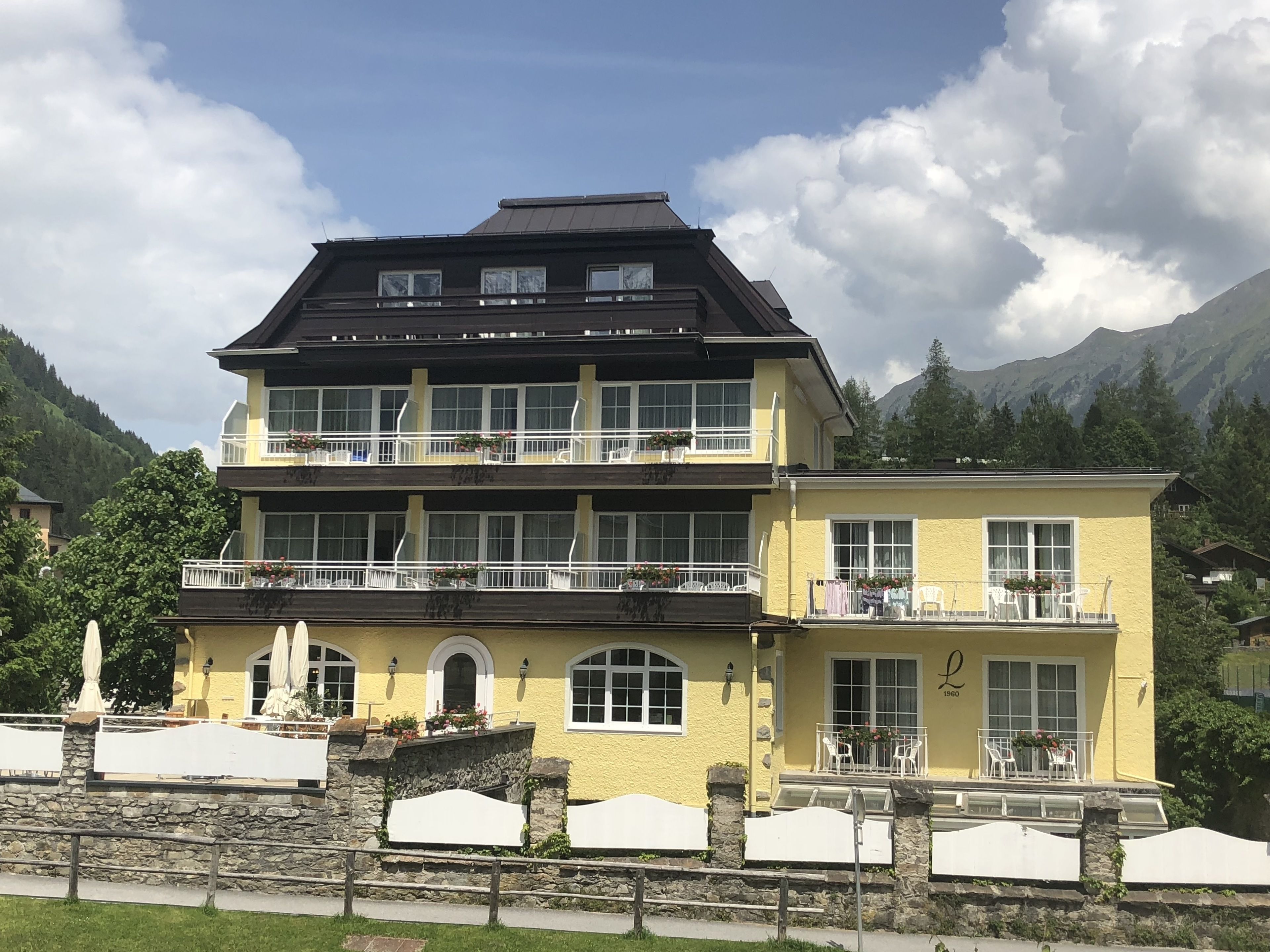 Un immeuble à deux étages, doté de balcons, de grandes fenêtres et d’une base en pierre.