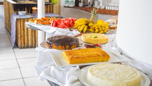 A buffet table with various desserts and fruits. - Garça Branca Praia Hotel (Porto Seguro)