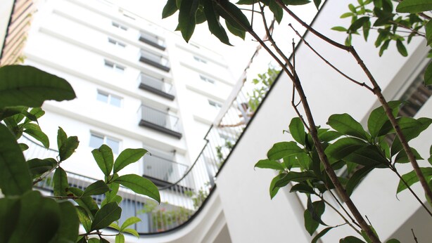 Vista de un edificio con balcones y fachada blanca.