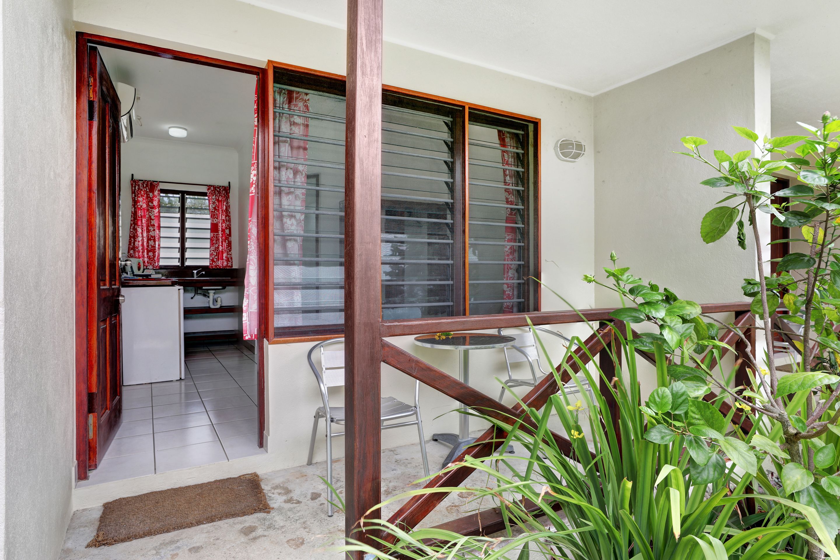 A residential interior with a kitchen, dining area, and a staircase leading to an upper floor.